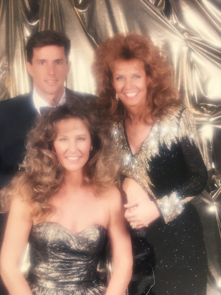 Three smiling people in metallic formal attire
