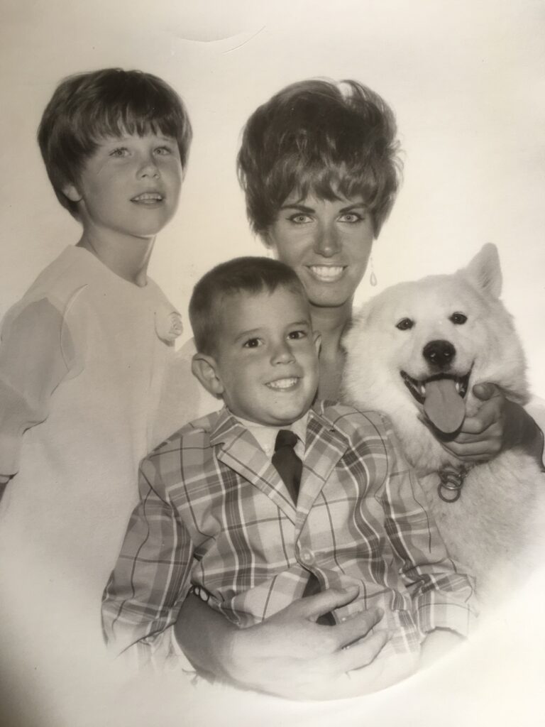 Black-and-white family portrait with smiling white dog