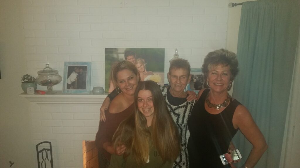 Four women smiling in living room