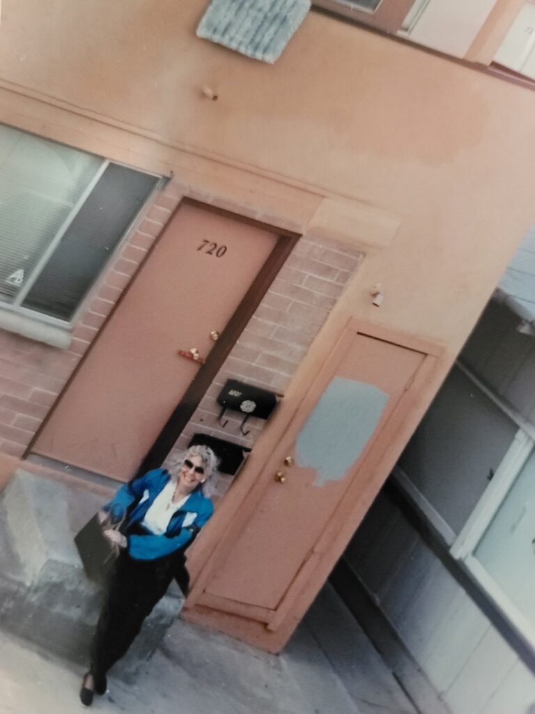 Woman standing outside peach colored apartment door 720
