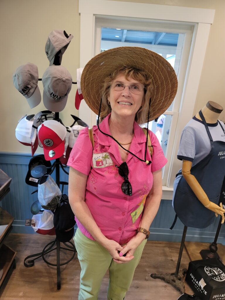 Smiling woman wearing straw hat in shop
