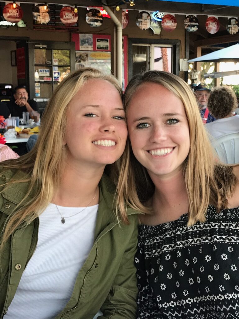 Two smiling young women at outdoor cafe