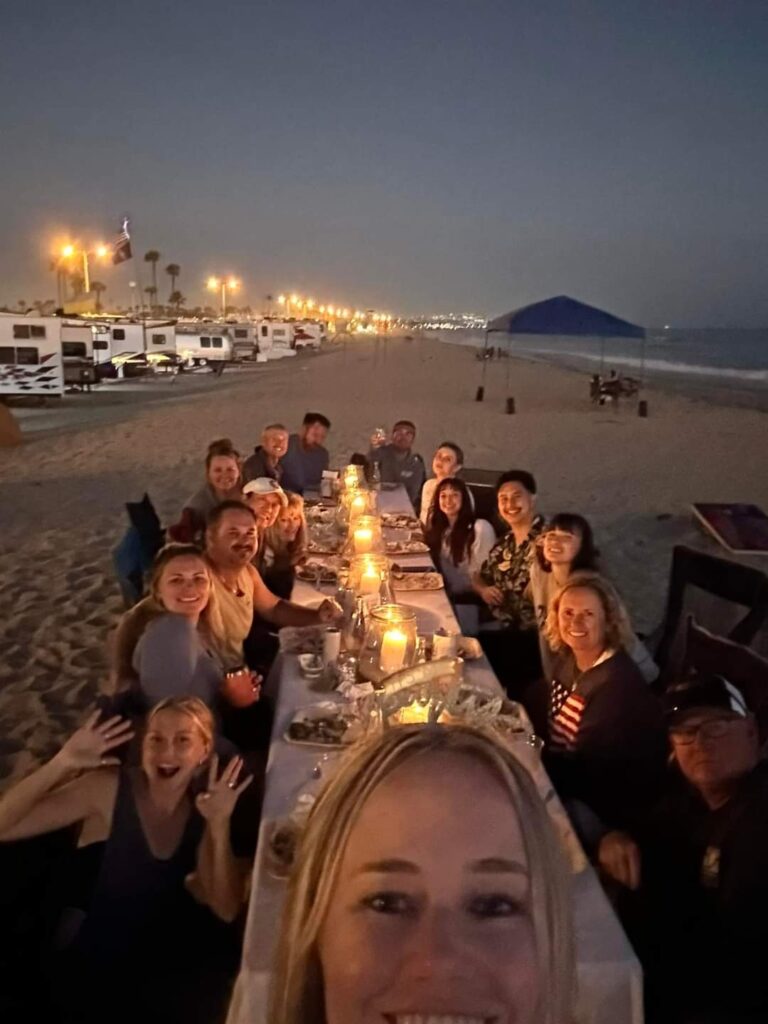 Candlelit beach dinner with large group